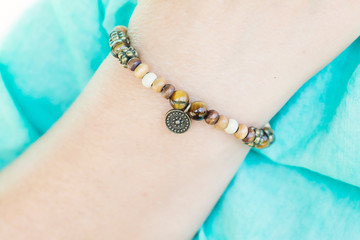 Mineral tyger eye and wooden beads bracelet on female wrist