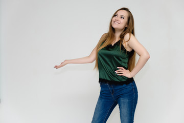 Concept portrait above the knee of a pretty girl, a young woman with long beautiful brown hair and a green t-shirt and blue jeans on a white background. In studio in different poses showing emotions.