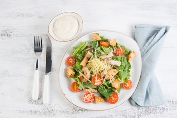 Traditional Italian Caesar salad with chicken, tomatoes and Parmesan