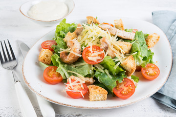 Fototapeta na wymiar Traditional Italian Caesar salad with chicken, tomatoes and Parmesan