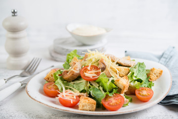 Traditional Italian Caesar salad with chicken, tomatoes and Parmesan