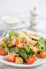 Traditional Italian Caesar salad with chicken, tomatoes and Parmesan