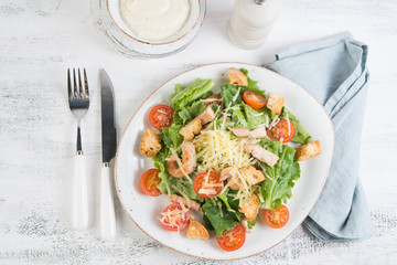 Traditional Italian Caesar salad with chicken, tomatoes and Parmesan