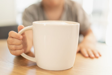 Obraz na płótnie Canvas Child holding a cup with foamed milk