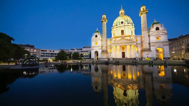 The beautiful Karlskirche (St. Karls Church) in Vienna, Austria at night with clean reflection in the water and deep blue sky.