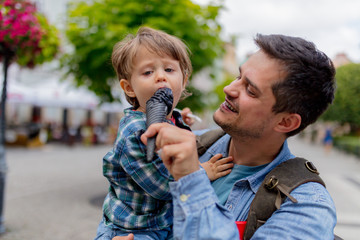 Dad and son have a fun with black ice-cream