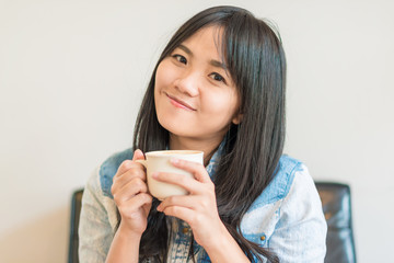 Beautiful asian women hold hot coffee cup in cafe