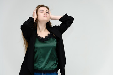 Concept portrait for the waist of a pretty girl, a young woman with long beautiful brown hair and a black jacket and blue jeans on a white background. In studio in different poses showing emotions.