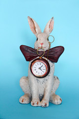 Obraz na płótnie Canvas sculpture ceramic gray hare with a clock for a home interior
