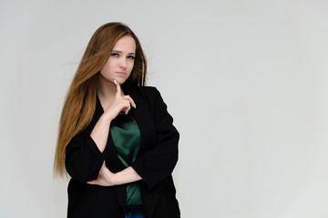 Concept portrait for the waist of a pretty girl, a young woman with long beautiful brown hair and a black jacket and blue jeans on a white background. In studio in different poses showing emotions.