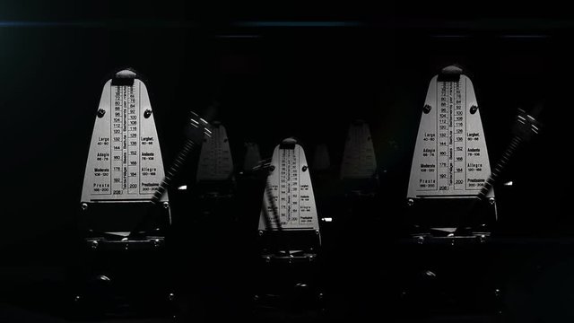 asynchronous swinging metronome on a black background