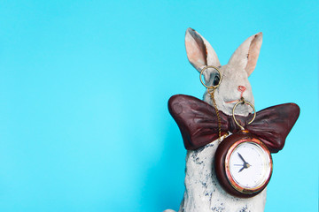 Fototapeta na wymiar sculpture ceramic gray hare with a clock for a home interior