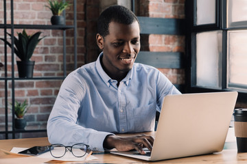 Modern african business man using laptop in modern loft office