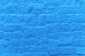 abstract background of stone wall painted in bright blue close up