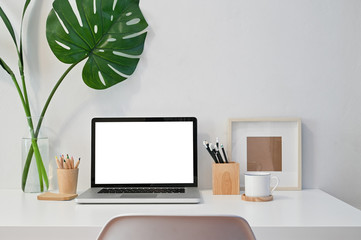 Workspace Laptop computer, coffee, pencil, photo frame and plant decoration on table.