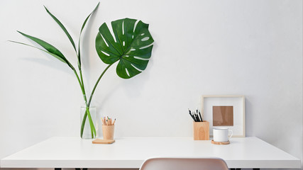 Workspace creative desk photo frame, coffee, pencil with plant decoration.