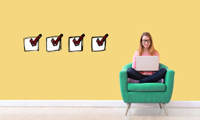 Checklist with young woman using her laptop in a chair