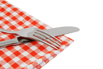 Knife and fork on red checked tablecloth isolated