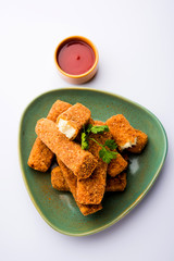 Kurkuri paneer fingers or pakora/pakoda snacks also known as Crispy Cottage Cheese Bars, served with tomato ketchup as a starter. selective focus