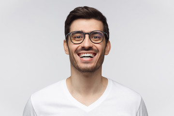 Laughing out loud. Joyful young man in casual t-shirt smiles broadly, laughing, showing perfect...