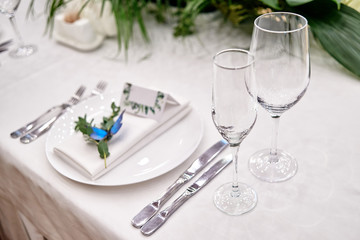 Table setting with sparcling wineglasses and cutlery on table, copy space. Menu mockup, place setting at wedding reception. Table served for wedding banquet in restauran