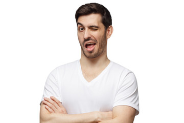 Fototapeta premium Young man winking isolated on white background