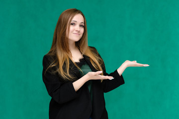 Concept portrait for a belt of a pretty girl, young woman with beautiful brown hair and in a black jacket and green T-shirt on a green background. In the studio in different poses showing emotions.