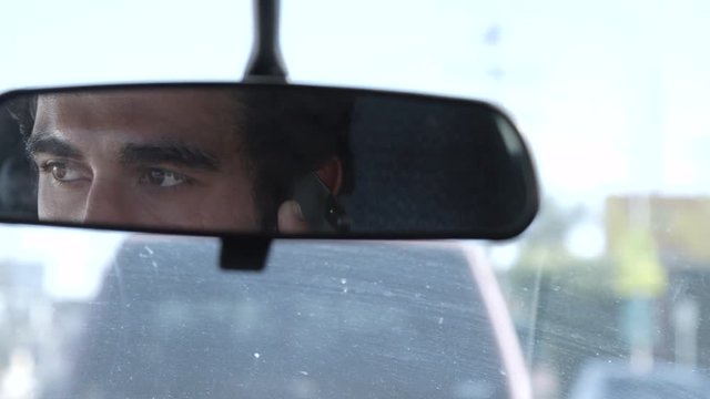 Middle eastern man on cell phone in car while vehicle is in traffic