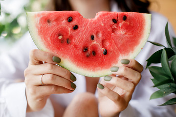 cute girl holding a piece of watermelon and smiling