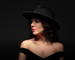 Fototapeta na wymiar Profile portrait of a beautiful lady wearing a black hat