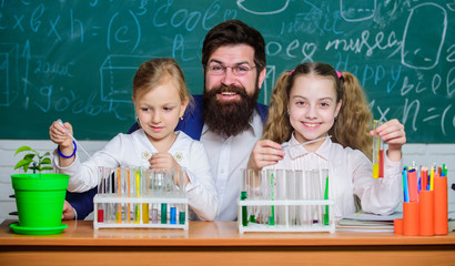 Man bearded teacher work with microscope and test tubes in biology classroom. School biology experiment. Explaining biology to children. How to interest children study. Fascinating biology lesson