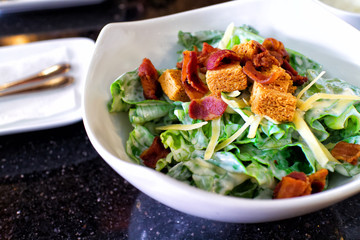 Fresh caesar salad on bowl with parmesan cheese and crispy bacon