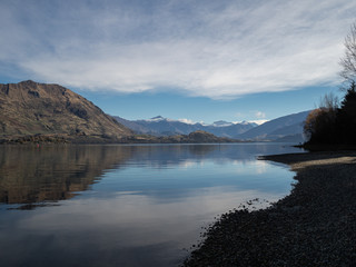 Shore of Lake Wanaka, New Zealand, with mountain reflected in the water
