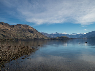 Shore of Lake Wanaka, New Zealand, with mountain reflected in the water