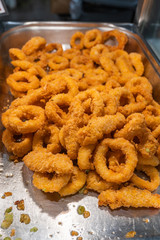 Deep fried batter squid rings on the tray for sale
