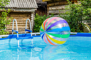 Large multicolored rainbow ball floats in the pool