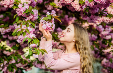 Fototapeta premium Look over there. summer. Childhood beauty. blossom smell, allergy. happy girl in cherry flower. Sakura tree blooming. skincare spa. Natural cosmetics for skin. small girl child in spring flower bloom