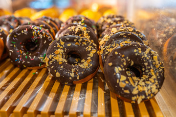 Delicious frosted chocolate donuts with sprinkle topping on the tray