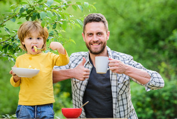 Fototapeta premium Father son eat food and have fun. Little boy and dad eating. Nutrition for kids and adults. Healthy nutrition concept. Feeding baby. Menu for children. Nutrition habits. Family enjoy homemade meal