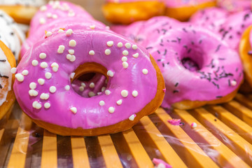 Pile of pink glazed donuts for sale at confectionery store