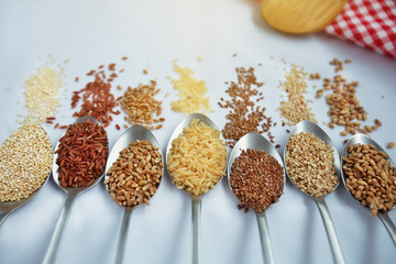 Seven spoon with grains and variations of rice with traditional italian napkin in the background