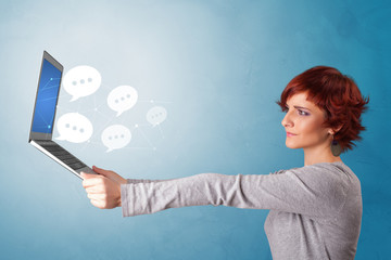 Woman holding laptop with a few speech bubble symbols