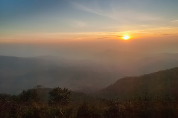Mountain view morning of top hill around with soft fog and yellow sun light in the sky background, sunrise at top of Phu Ruea National Park, Phu Ruea District, Loei Province, Thailand.