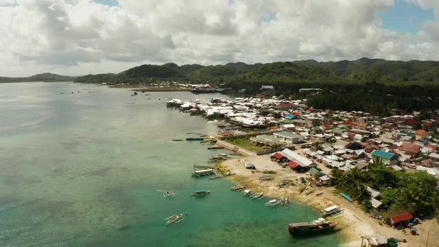 Old wooden house standing on the sea in the fishing village, aerial view. Dapa, Siargao, Philippines.