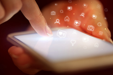 Finger touching phone with social media concept and dark background