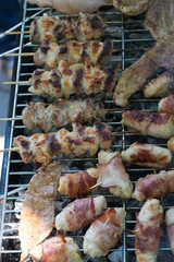 closeup of some meat on Wooden skewers being grilled in a barbecue. Grilling marinated shashlik on a coal grill. Food and Cuisine. Barbeque Chicken