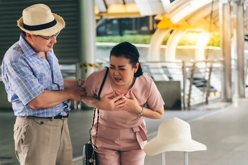 Naklejka premium The husband is worried about the Asian wife, are suffering from angina Due to heart disease, During travel, to elder and health concept.