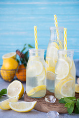 Homemade lemonade with lemon, mint and ice in bottles