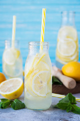 Homemade lemonade with lemon, mint and ice in bottles