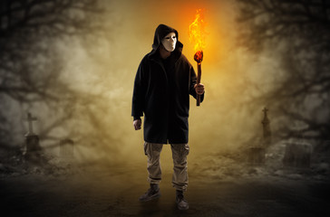 Man with burning flambeau coming from thicket and looking something